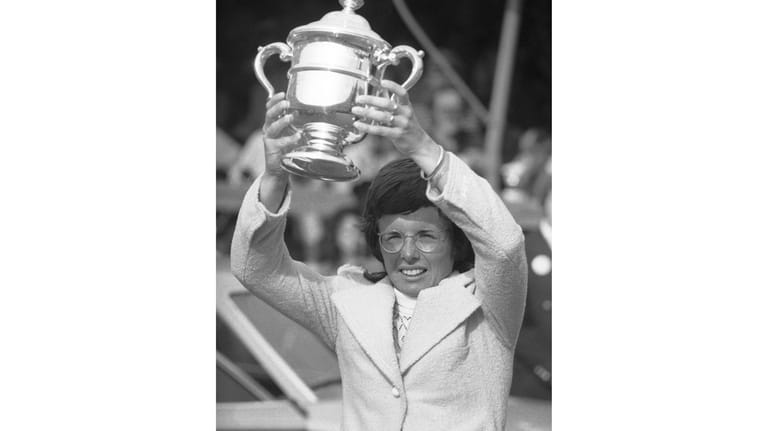 Billie Jean King holds up trophy she received in the...
