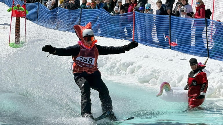 A skier participates in a pond skimming event at Gunstock...
