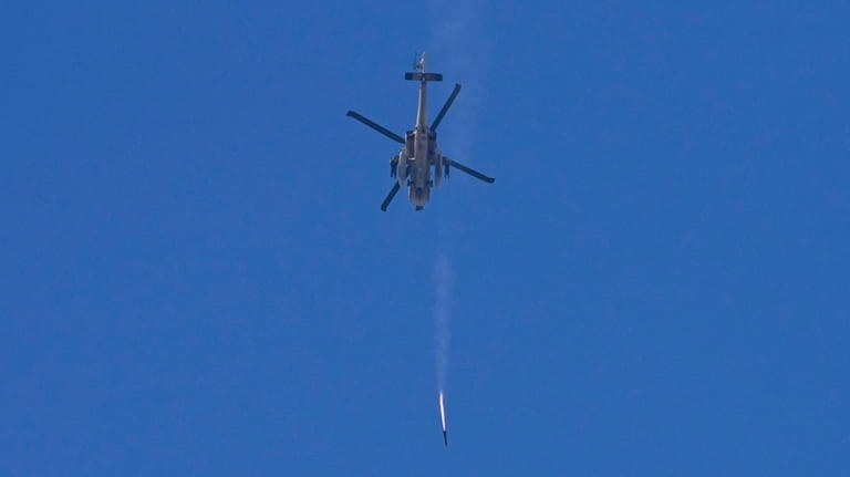 An Israeli Apache helicopter fires a missile in direction of...