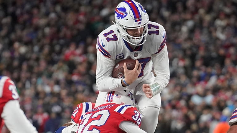Buffalo Bills quarterback Josh Allen (17) leaps high while tackled...