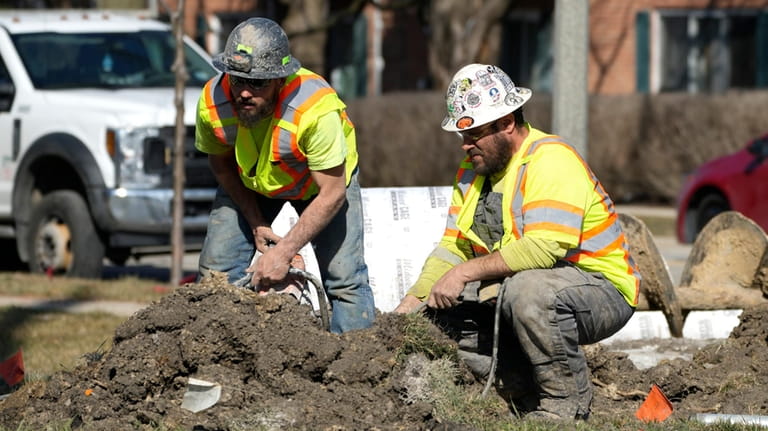 Construction workers work in Mount Prospect, Ill., Monday, Feb. 26,...