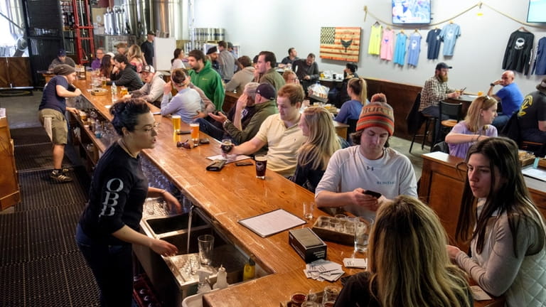 Patrons sip on a variety of beers in the tasting...