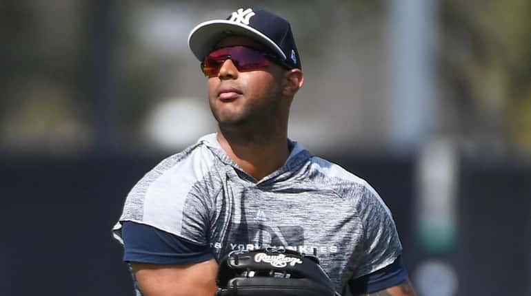Yankees centerfielder Aaron Hicks warms up during spring training workouts at...