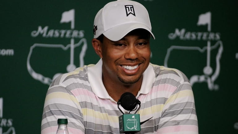 Tiger Woods smiles as he addresses members of the media...