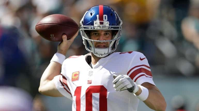 New York Giants' Eli Manning passes during the first half...