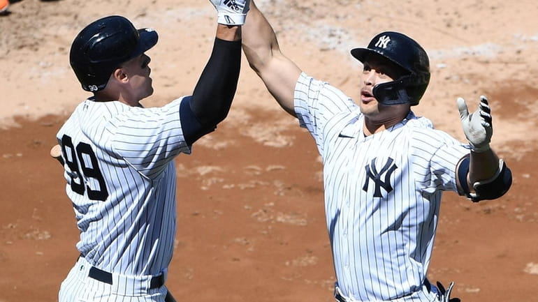 Yankees designated hitter Giancarlo Stanton, right, celebrates his solo home...