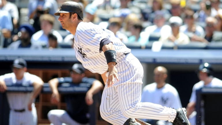 New York Yankees catcher Jorge Posada (20) hits a single...