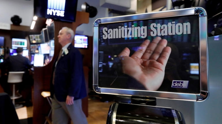 A trader passes a hand sanitizing station on the floor...