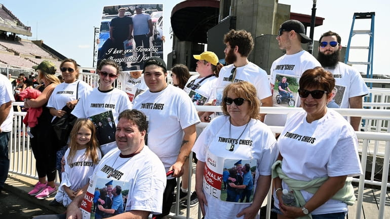 Members of the Carpenter family, wearing photos of their deceased son...