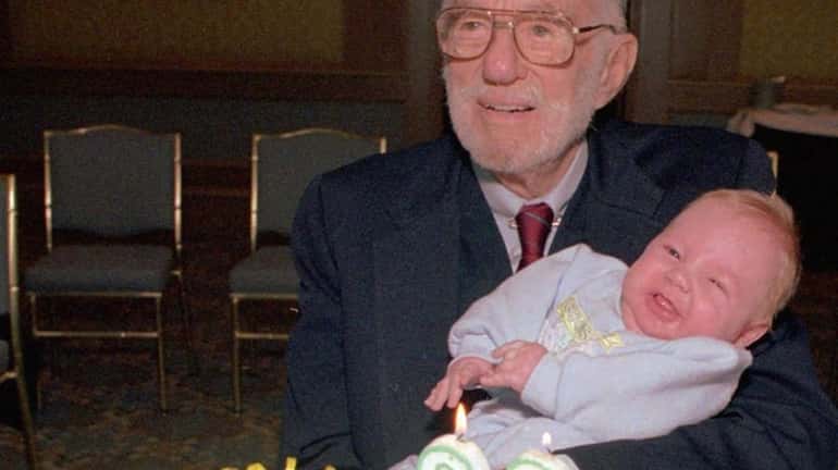 Dr. Benjamin Spock holds 3-month-old child at a Boston baby...