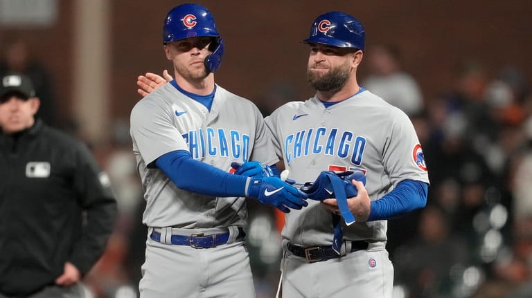 Chicago Cubs' Nico Hoerner, left, is congratulated by first base...