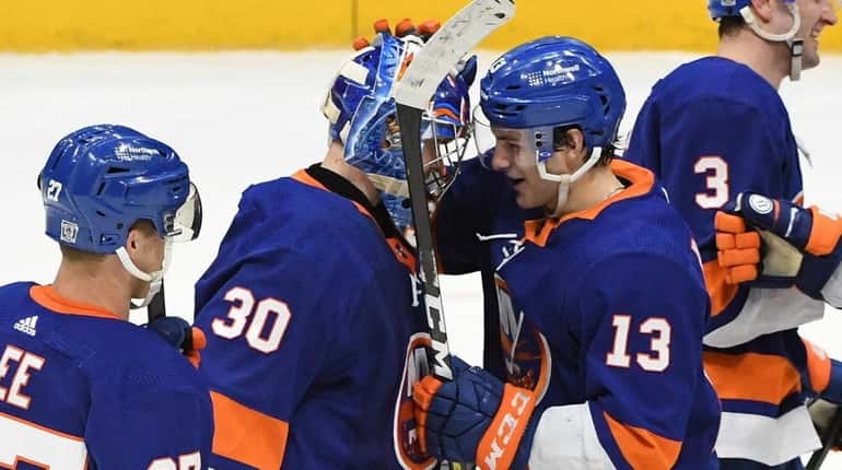 Islanders teammates congratulate goaltender Ilya Sorokin on the 2-0 shutout...