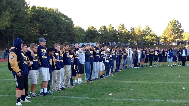 Students gather on the football field at Shoreham-Wading River High...