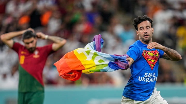 A pitch invader runs across the field with a rainbow...