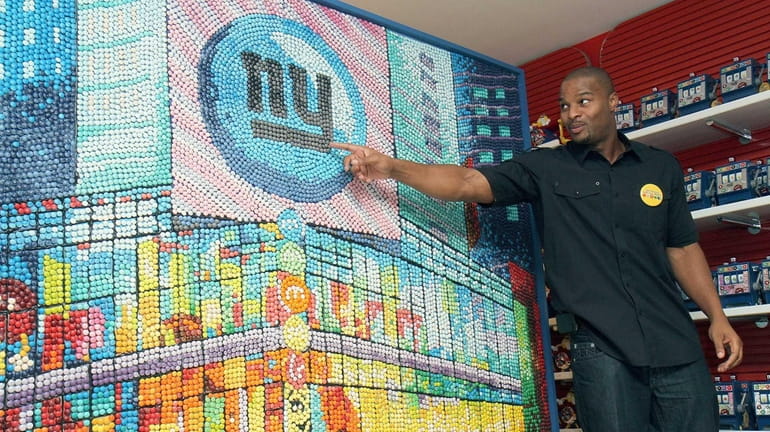 Osi Umenyiora stands in front of a Giants mosaic made...