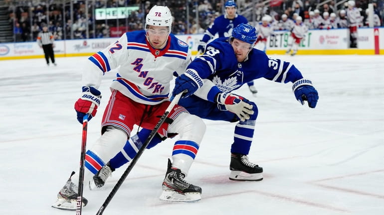 Rangers forward Filip Chytil (72) protects the puck from Toronto...