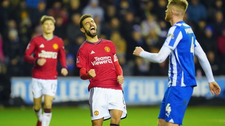 Manchester United's Bruno Fernandes, centre, celebrates after scoring his side's...