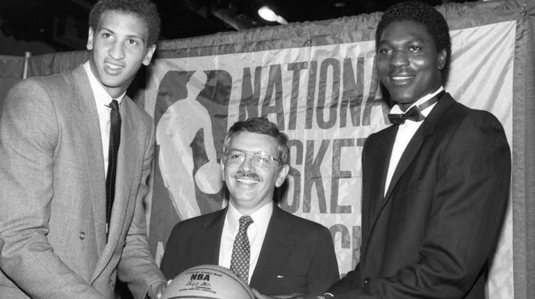 NBA commissioner David Stern, center, is flanked by Akeem Olajuwon,...