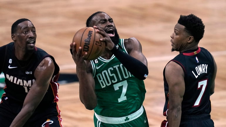 Boston Celtics guard Jaylen Brown, center, shoots as Miami Heat...