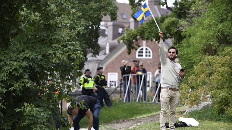 Protestor Salwan Momika waves the Swedish flag outside the Iraqi...
