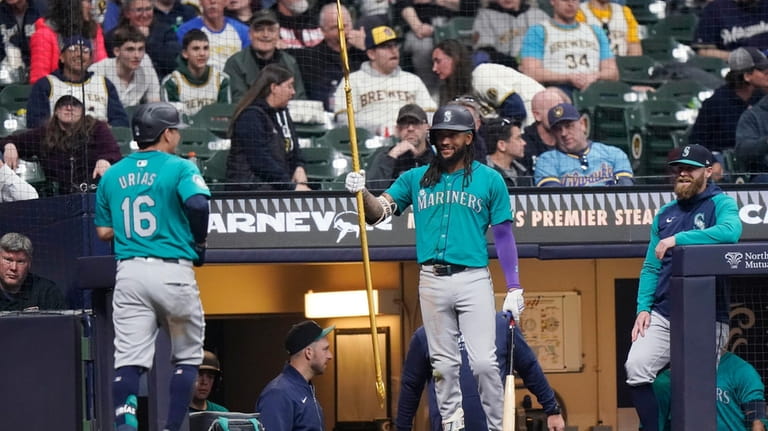 Seattle Mariners' Luis Urías (16) is congratulated at the dugout...