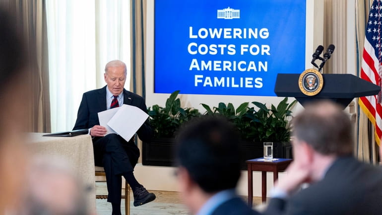 President Joe Biden sits after speaking during a meeting with...