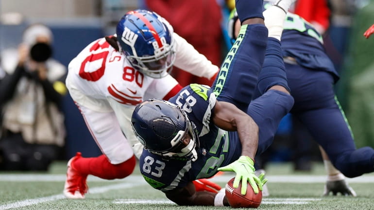 Dareke Young of the Seahawks recovers a fumble by Richie James of...