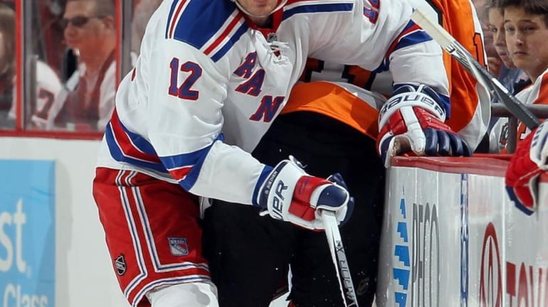 Olli Jokinen #12 of the New York Rangers checks Simon...