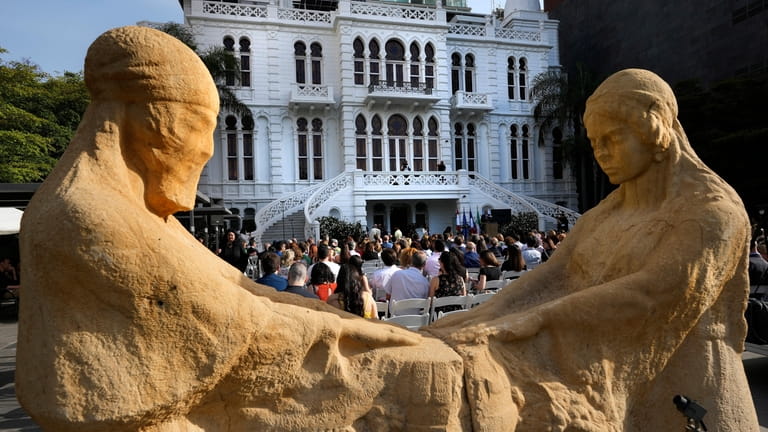 People gather in front of two sculptures at the courtyard...