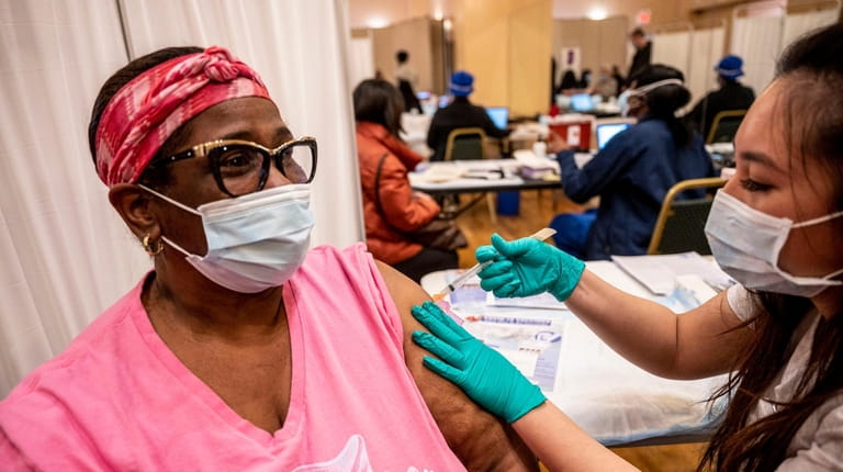 Jeinine Jones-Ford, of Uniondale, gets her first dose of the...