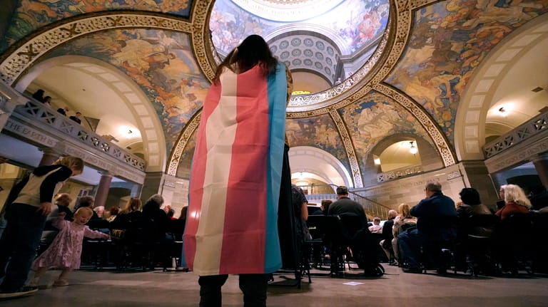 Glenda Starke wears a transgender flag as a counter protest...