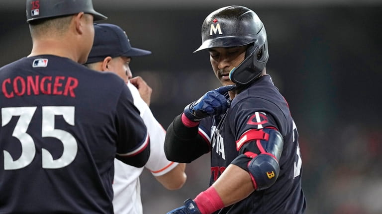 Minnesota Twins' Donovan Solano, right, points to his shoulder after...