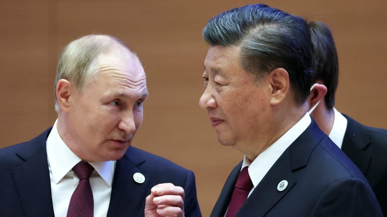 Russian President Vladimir Putin, left, gestures while speaking to Chinese...