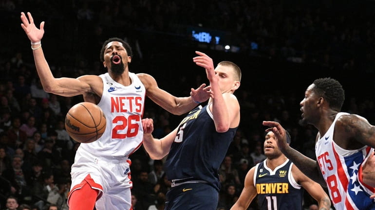 Brooklyn Nets guard Spencer Dinwiddie loses possession defended by Denver...