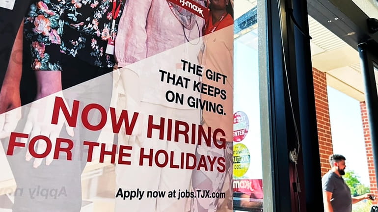 A hiring sign is displayed at a retail store in...