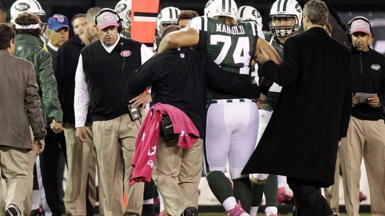 New York Jets head coach Rex Ryan watches as trainers...