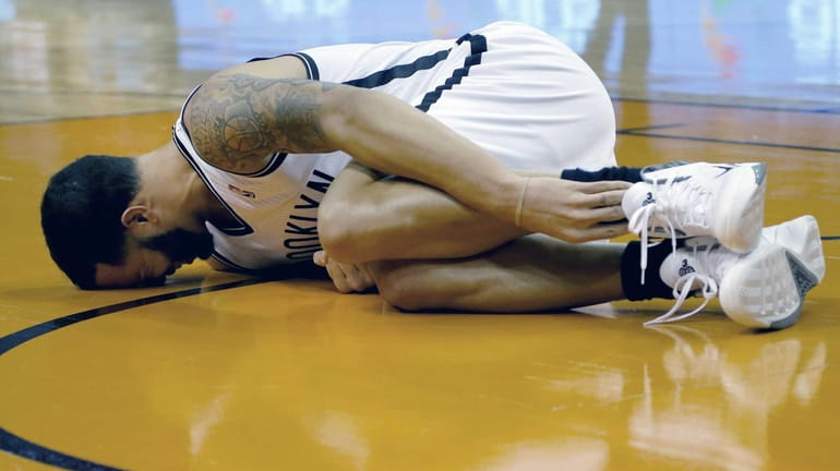 Nets' Deron Williams grabs his leg after being injured against...