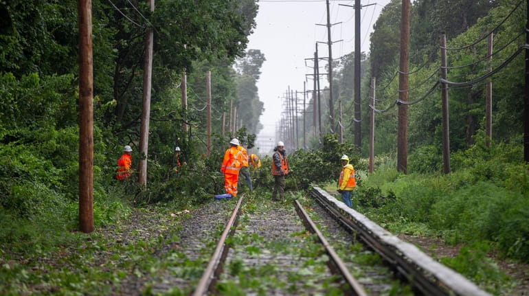 Crews work on clearing a tree blocking the tracks just...