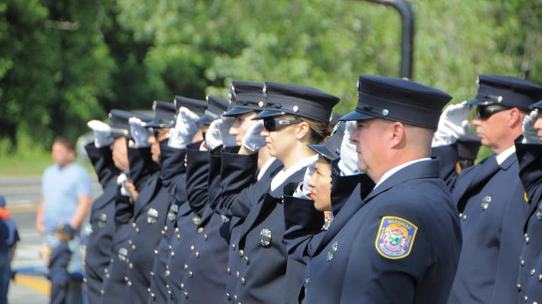 Members of Riverhead’s Fire Department salute during the Memorial Day processional...