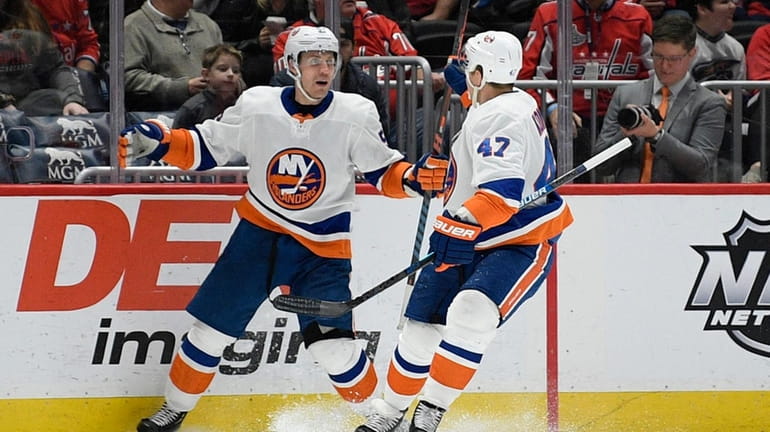 Islanders center Casey Cizikas, left, celebrates his goal with right...