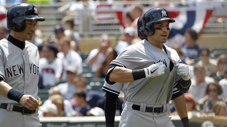 The Yankees' Jacoby Ellsbury gestures to his teammates after hitting...