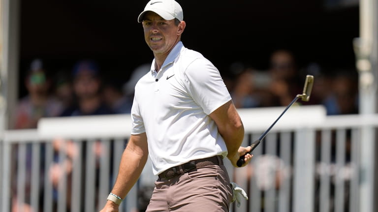 Rory McIlroy, of Northern Ireland, reacts to missing a putt...