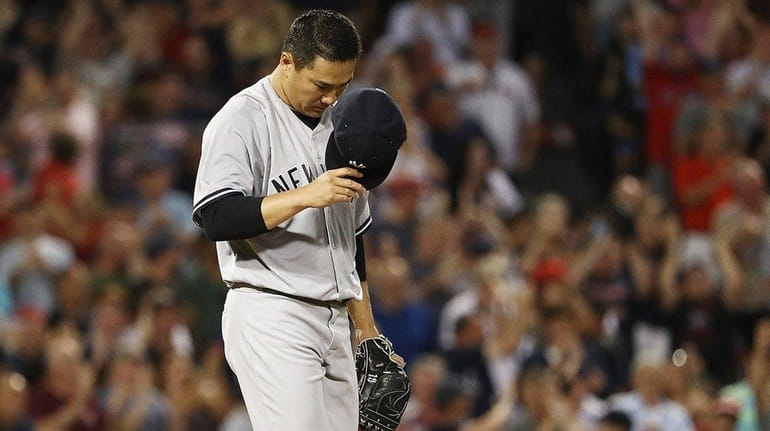 Masahiro Tanaka of the Yankees reacts after giving up a...