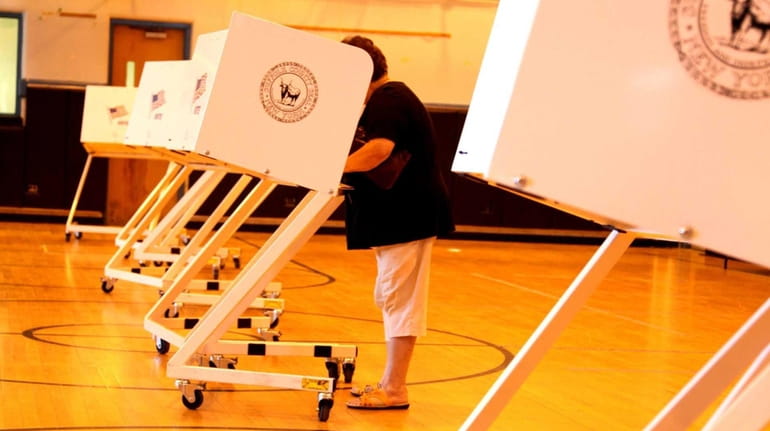 A resident casts a vote at a polling place in...