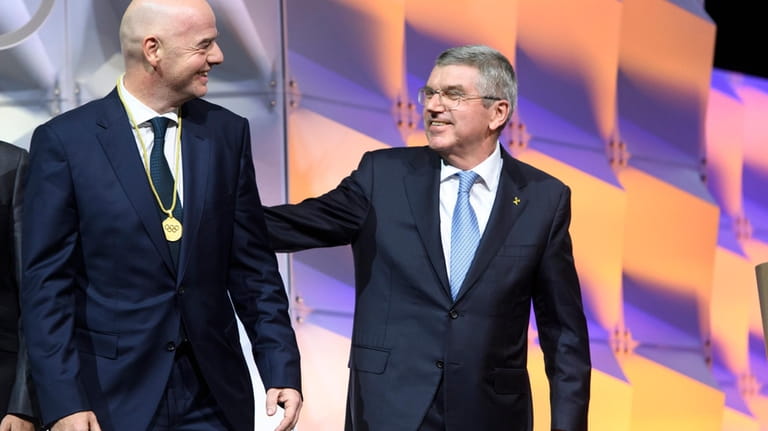FIFA President Gianni Infantino, left, speaks with IOC president Thomas...