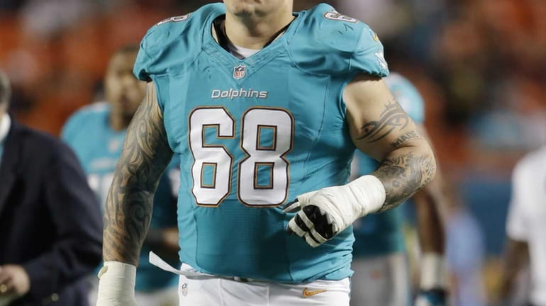 Miami Dolphins guard Richie Incognito walks across the field for...