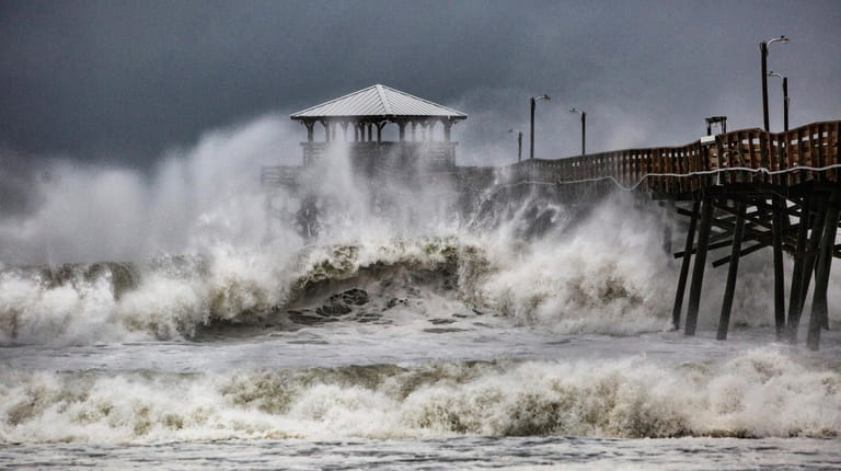 Waves slam the Oceana Pier & Pier House Restaurant in...