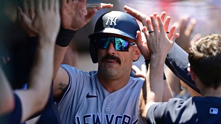 New York Yankees' Matt Carpenter is congratulated in the dugout...