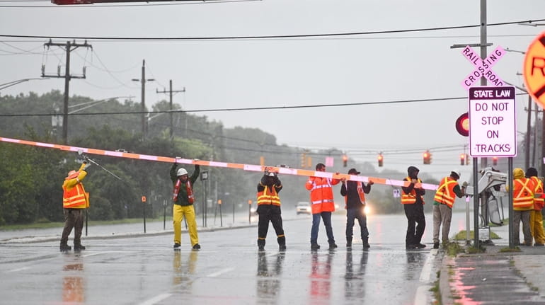 Long Island Rail Road workers try to free a downed...