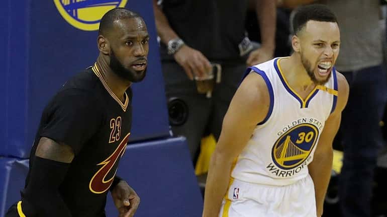 Warriors guard Stephen Curry reacts after scoring next to Cavaliers...
